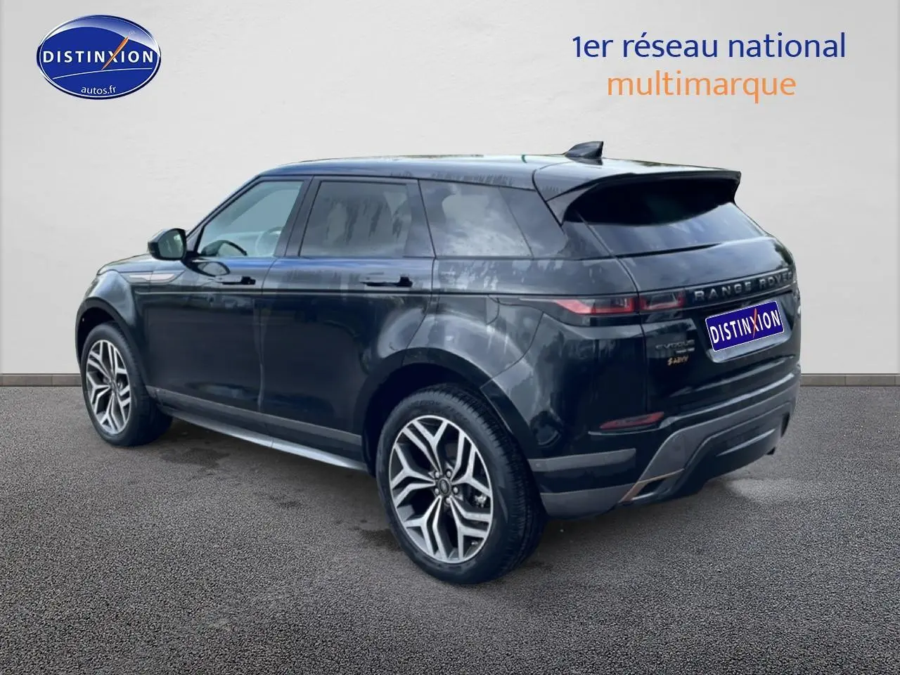 Range Rover Evoque noir vu en 3/4 arrière droit, avec jantes alliage et toit panoramique visible.