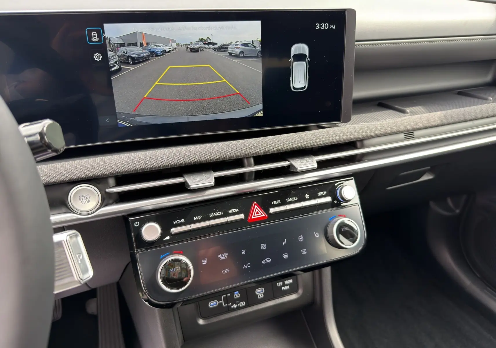Vue intérieure du tableau de bord du Hyundai Tucson 1.6 Hybrid 239 Creative 2026, avec écran tactile affichant la caméra de recul.