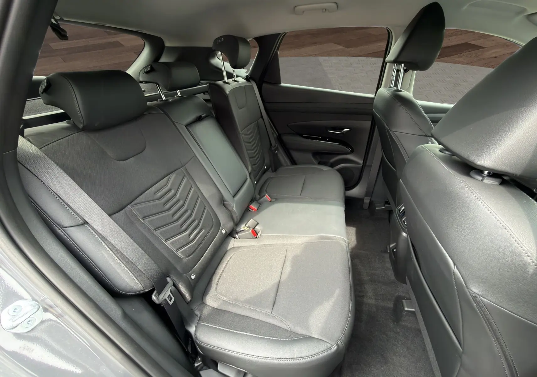 Vue intérieure côté droit des sièges arrière en cuir noir du Hyundai Tucson 1.6 Hybrid 239 Creative Auto gris foncé.