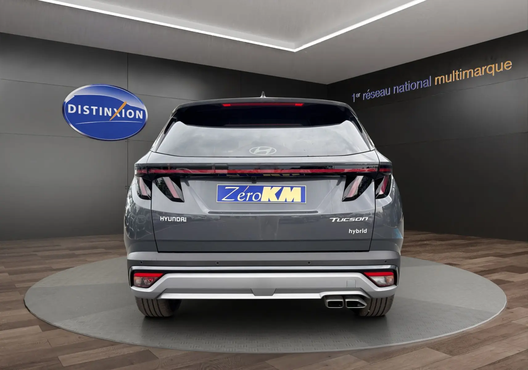 Vue arrière d'un Hyundai Tucson gris foncé hybride 2026 avec feux LED et double sortie d'échappement carrée.