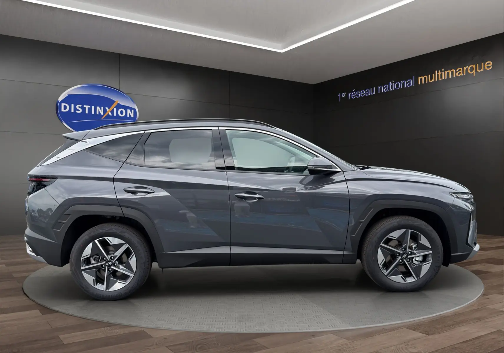 Vue latérale droite d’un Hyundai Tucson gris foncé 2026 avec jantes alliage et lignes anguleuses marquées.