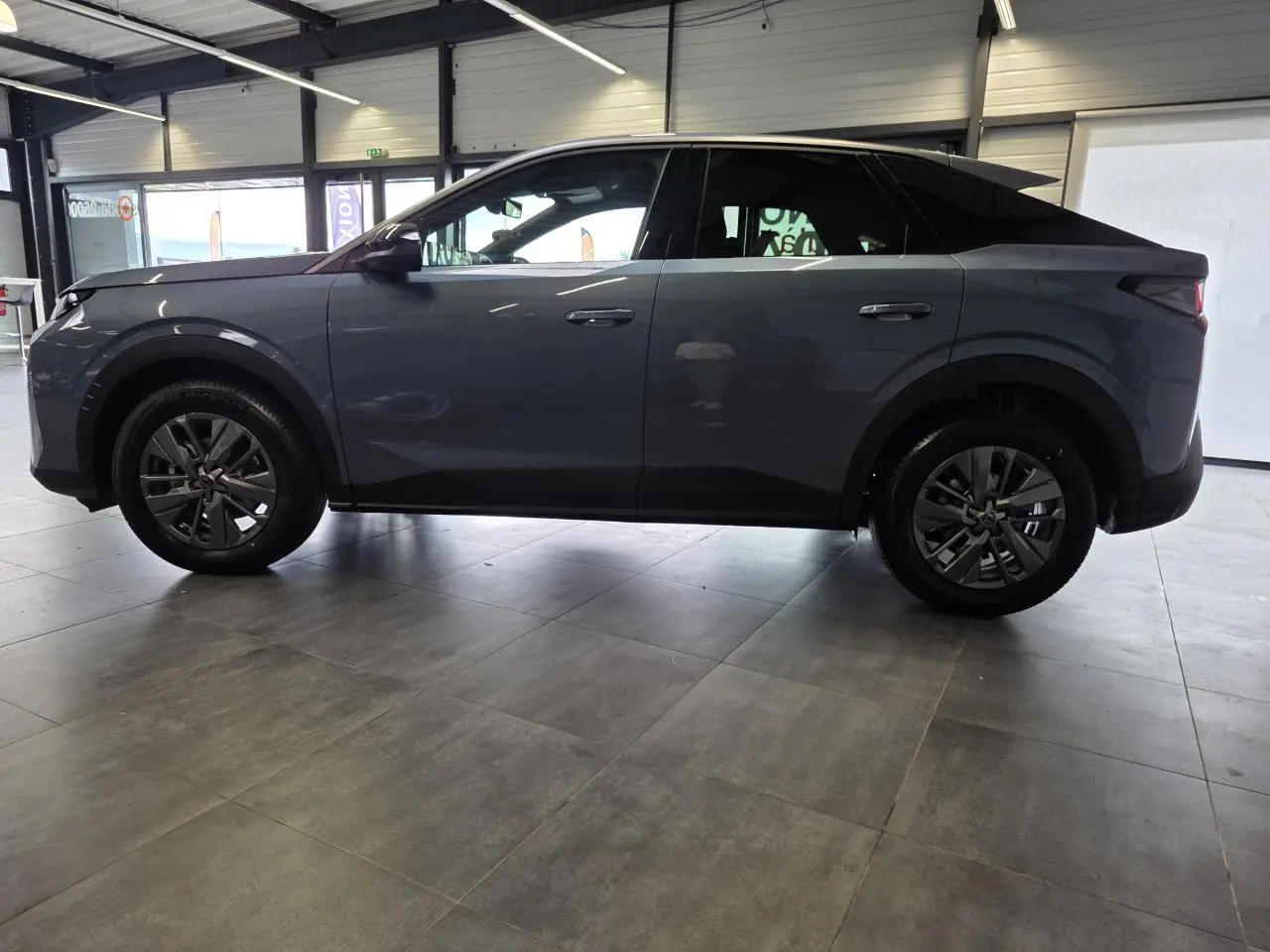 Profil côté gauche du Peugeot 3008 hybride bleu métallisé 2026, avec jantes alliage 18 pouces et détails noirs.