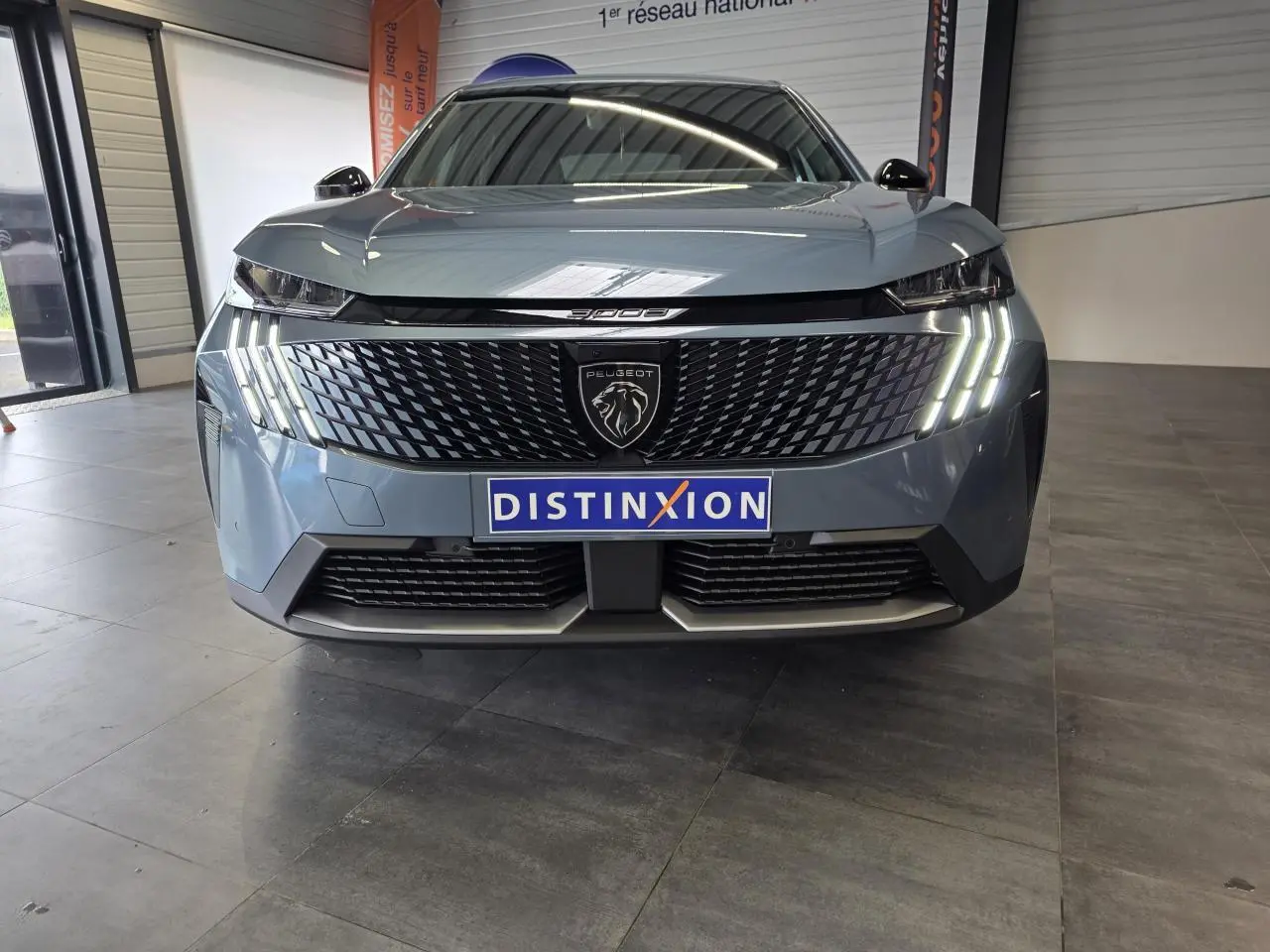 Vue avant frontale du Peugeot 3008 bleu avec calandre noire et feux LED à trois griffes allumés.