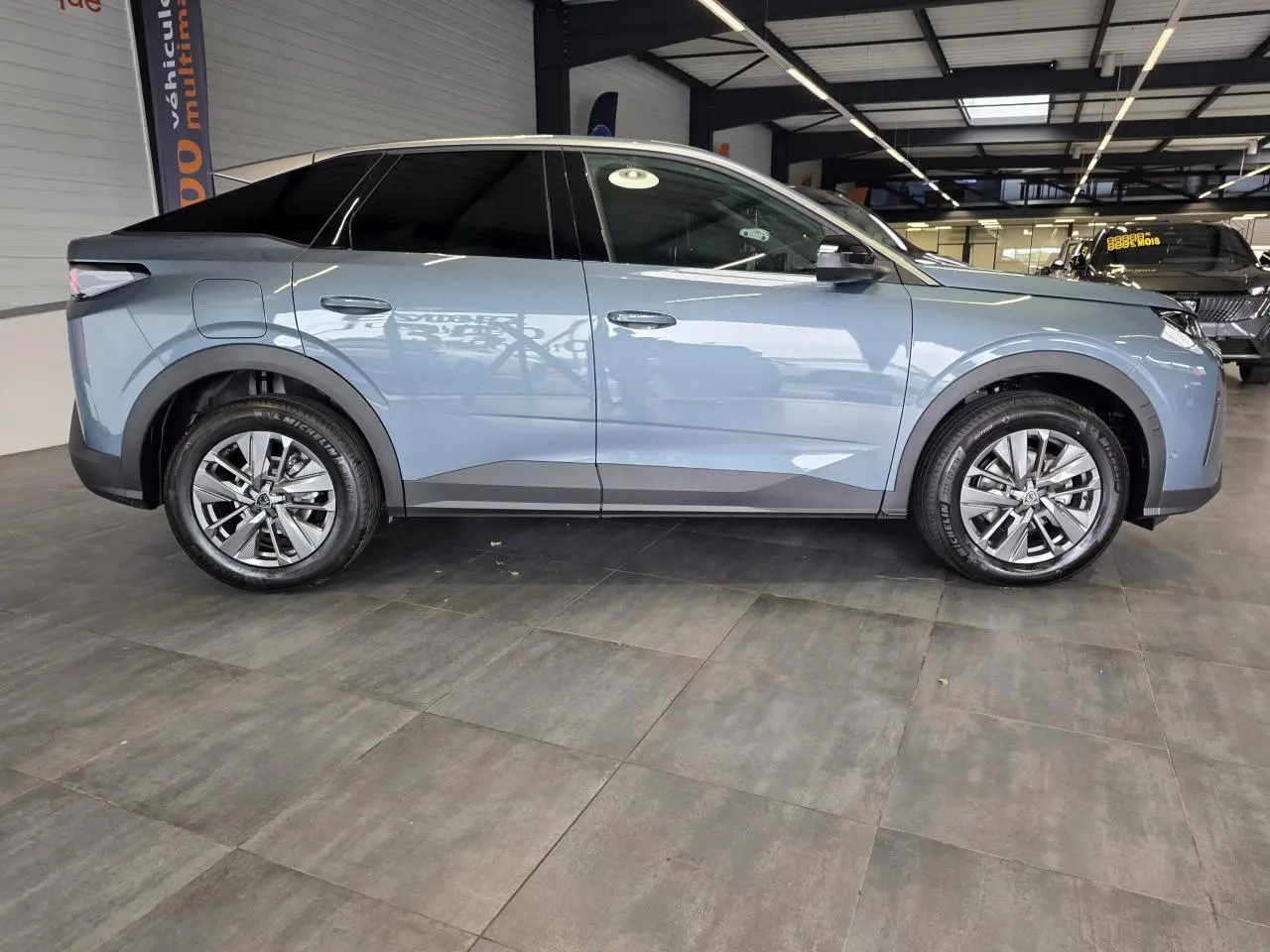 Peugeot 3008 hybride bleu vue de profil côté gauche en intérieur avec jantes alliage 18 pouces.