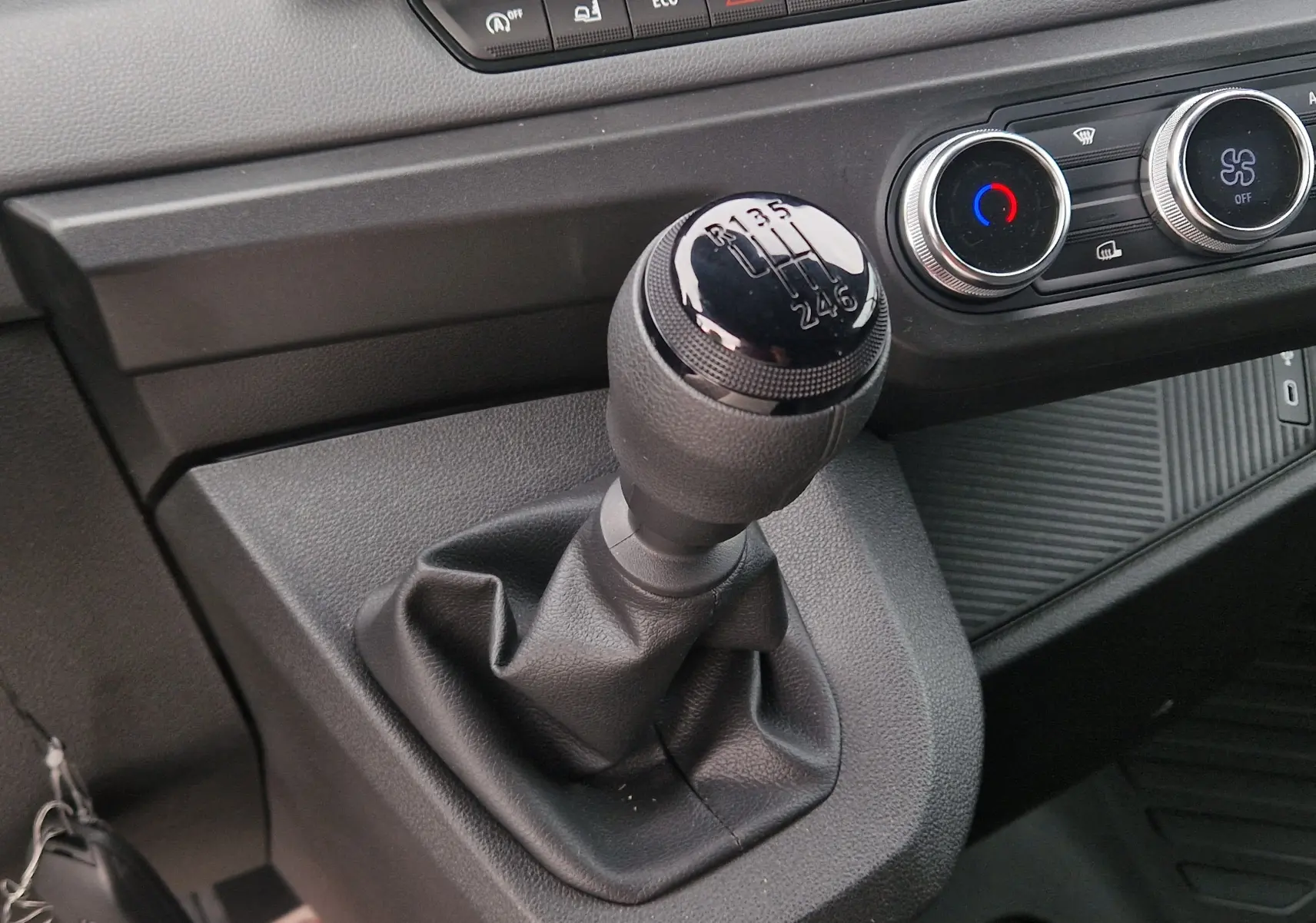 Gros plan intérieur sur le levier de vitesses manuel noir du Renault Master L2H2 2026 avec commandes de climatisation visibles.