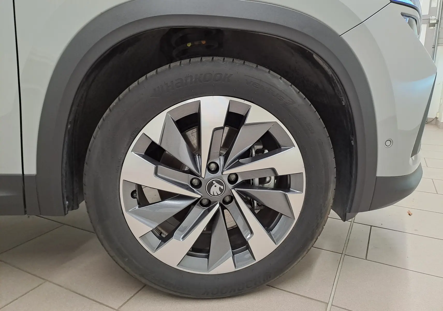 Gros plan sur la roue avant droite du Skoda Kodiaq gris perle, mettant en valeur la jante alliage 19'' Lefka anthracite.