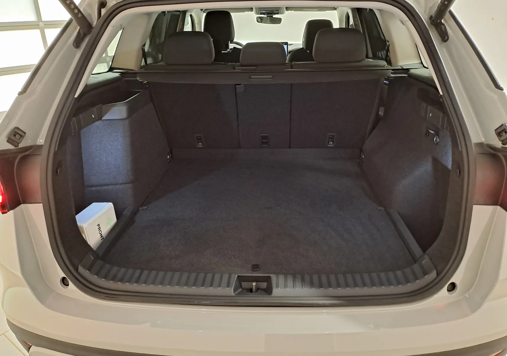 Vue arrière du coffre ouvert d'un Skoda Kodiaq gris perle 2025, montrant un espace de chargement spacieux et propre.