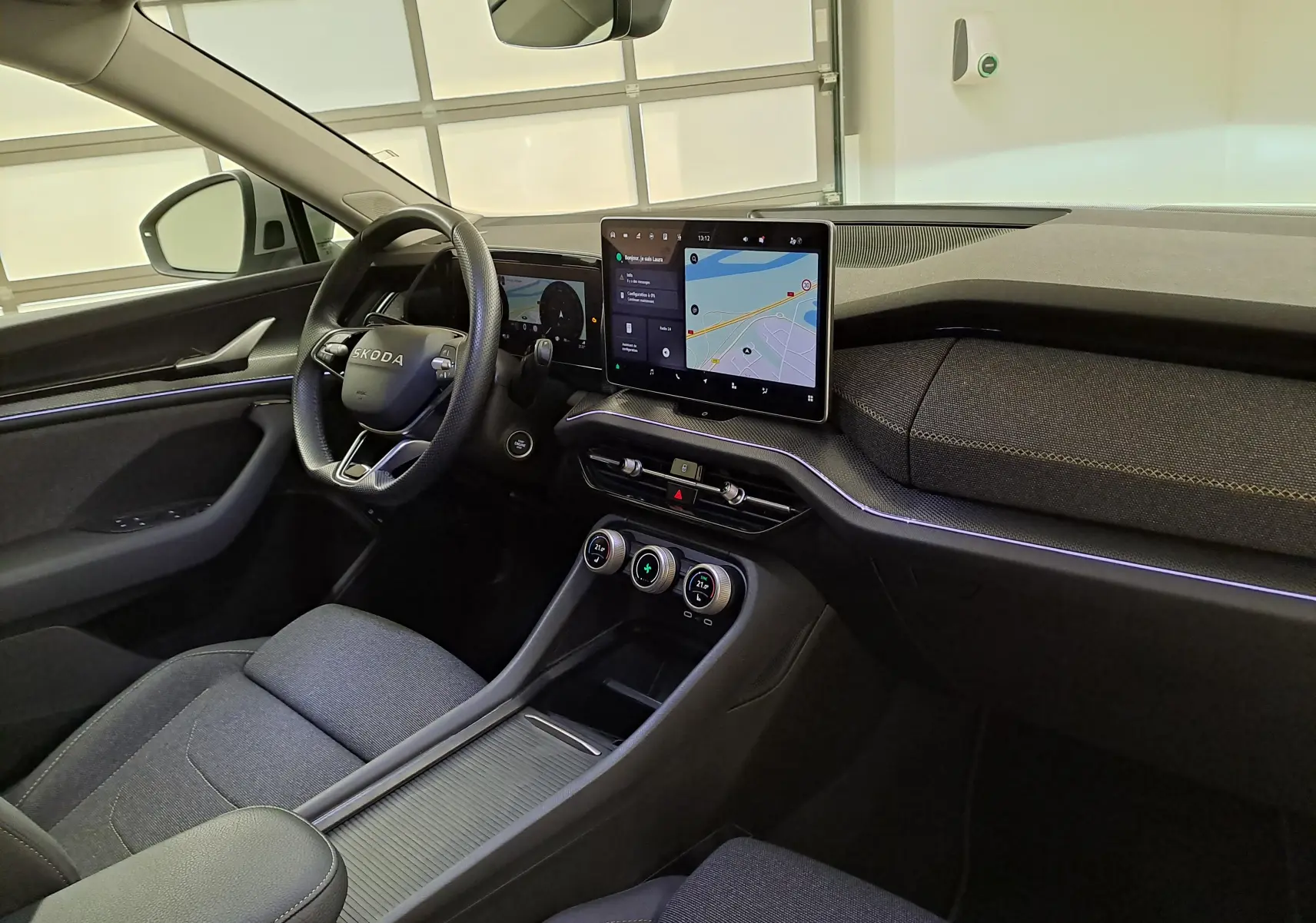 Vue intérieure côté conducteur du Skoda Kodiaq 2025 gris perle, avec écran tactile central et volant multifonction.