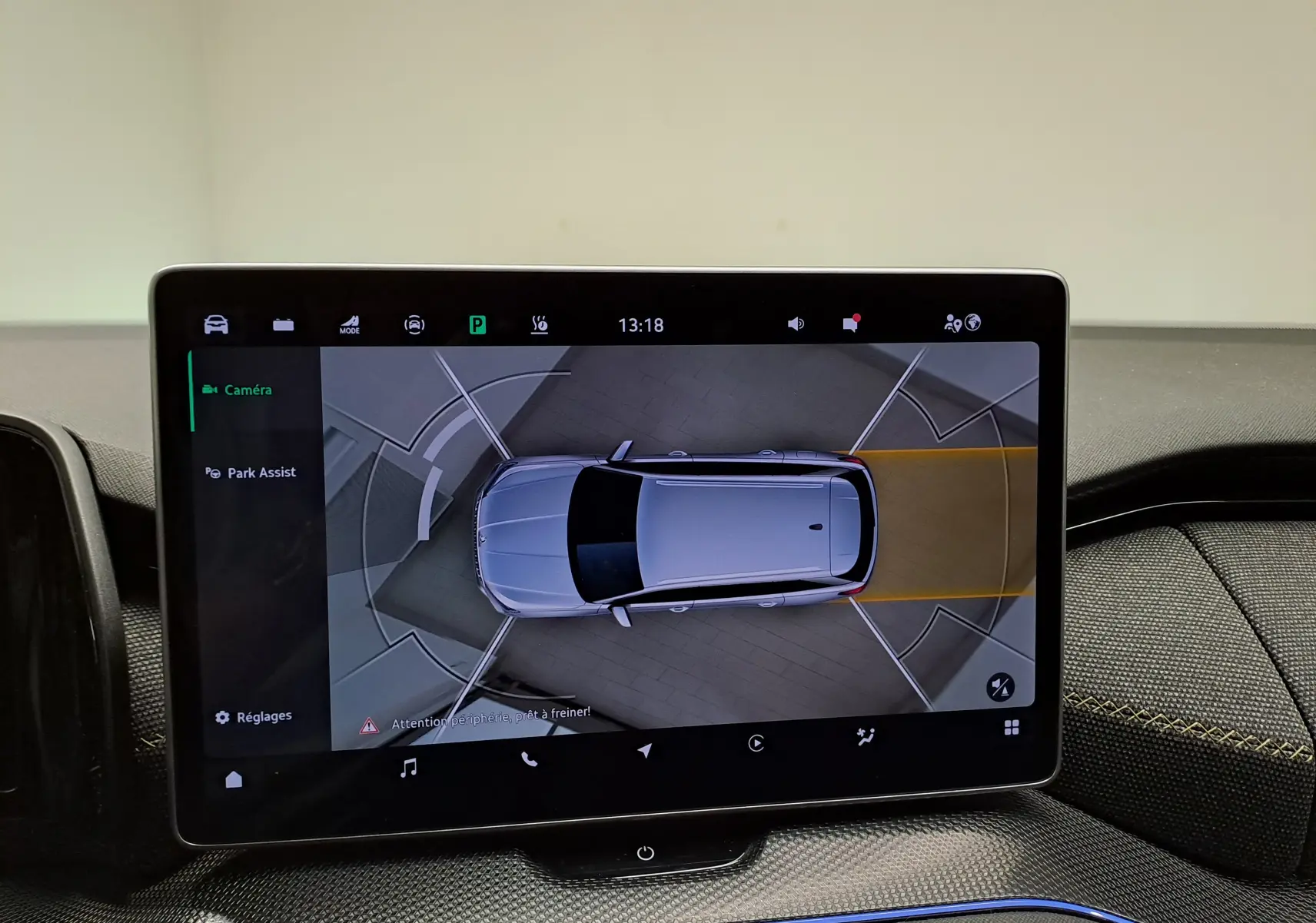 Écran intérieur montrant la vue aérienne du Skoda Kodiaq gris perle en stationnement assisté.