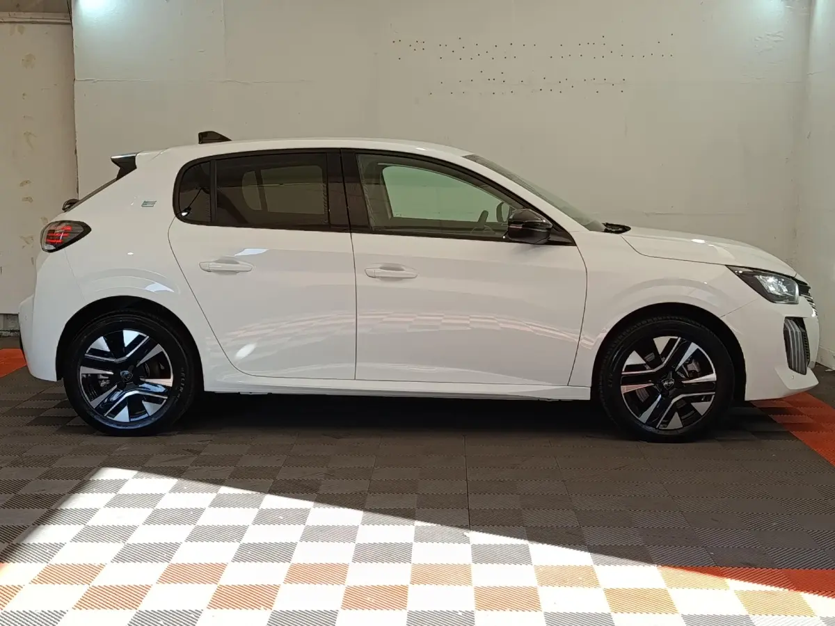 Peugeot 208 électrique blanc vue de profil côté gauche, avec jantes noires et détails modernes sur les phares.