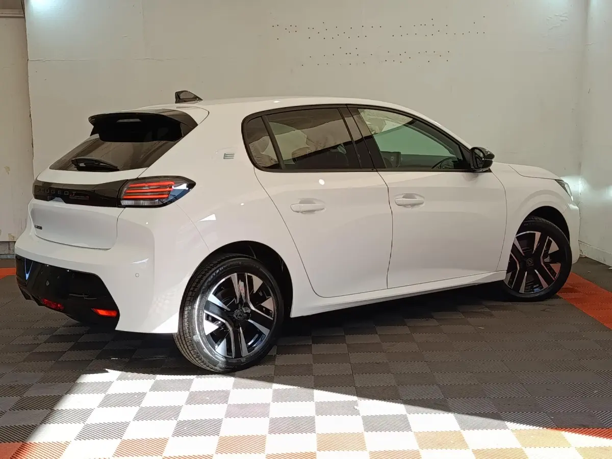 Peugeot 208 électrique blanche vue de profil droit arrière, avec feux LED et jantes noires distinctives.