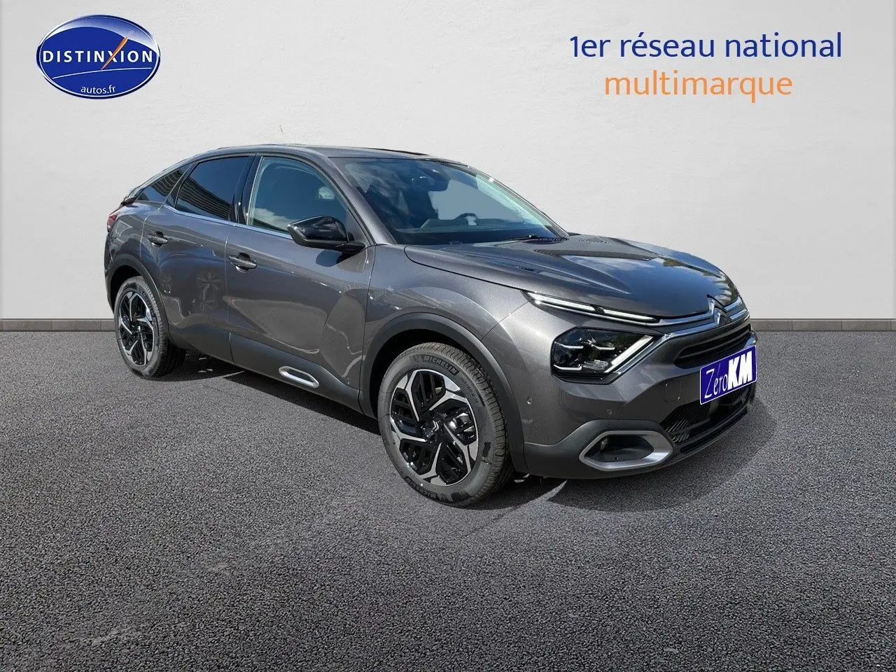 Citroën C4 gris platinium métal vue 3/4 avant droit, mettant en valeur ses lignes fluides et ses jantes noires bicolores.