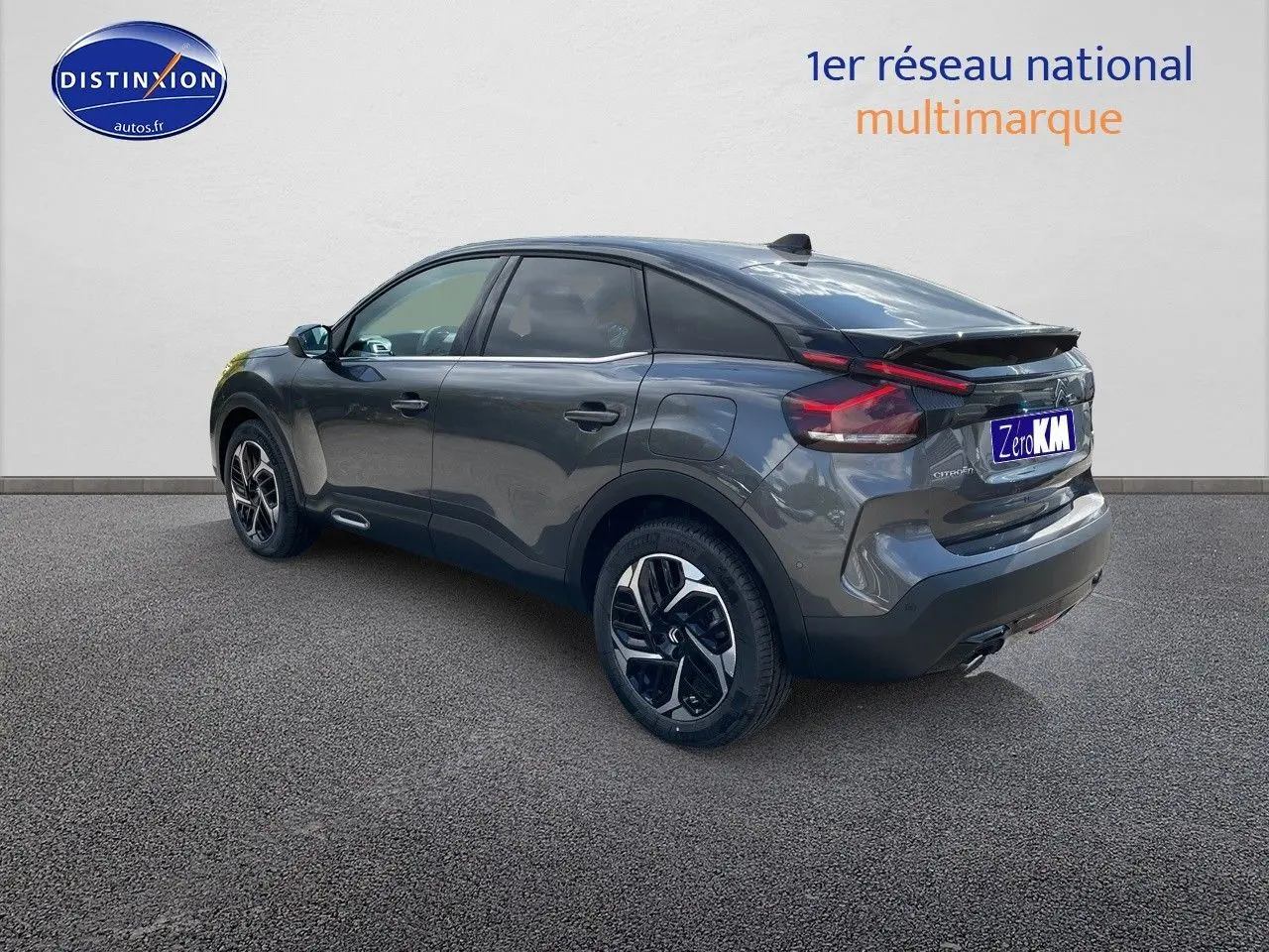 Citroën C4 gris platinium métal vue 3/4 arrière droit, mettant en valeur ses feux LED et jantes bicolores.