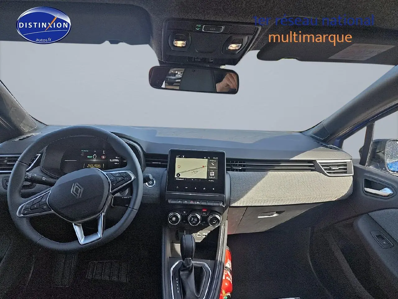 Intérieur avant de la Renault Clio V bleu iron 2025, tableau de bord moderne avec écran tactile et volant multifonction.