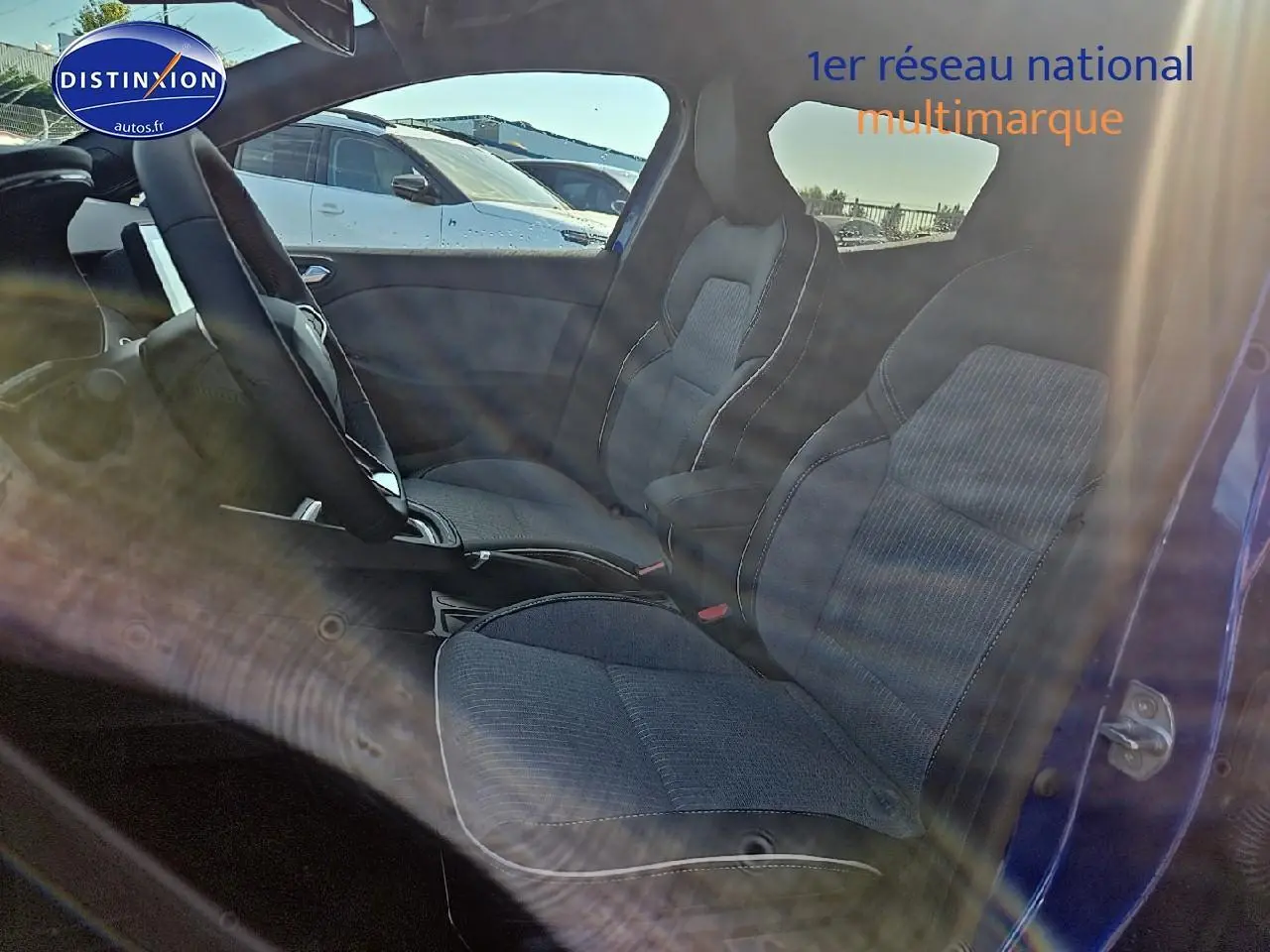 Vue latérale intérieure des sièges avant sport gris foncé de la Renault Clio V Bleu Iron avec porte ouverte côté droit.
