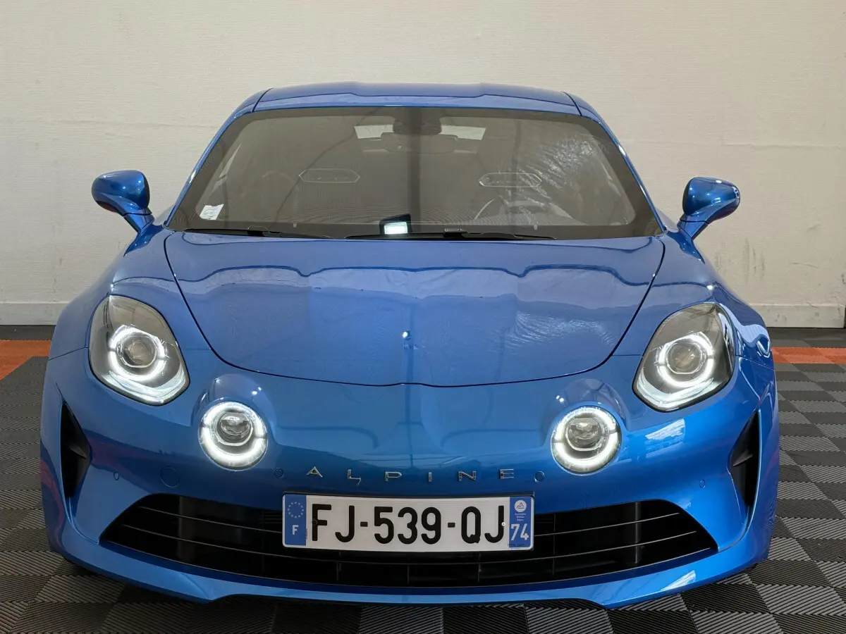 Vue avant d'une Alpine A110 Legende 2019 bleu électrique avec ses phares LED ronds distinctifs allumés.