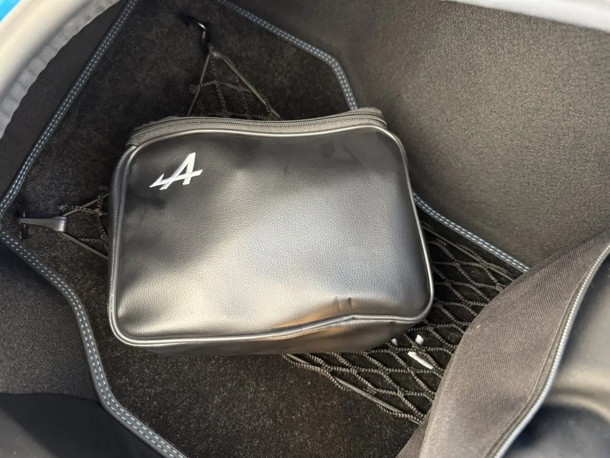 Sacoche noire avec logo Alpine dans le coffre avant d'une Alpine A110 Legende bleu 2019 vue en plongée.