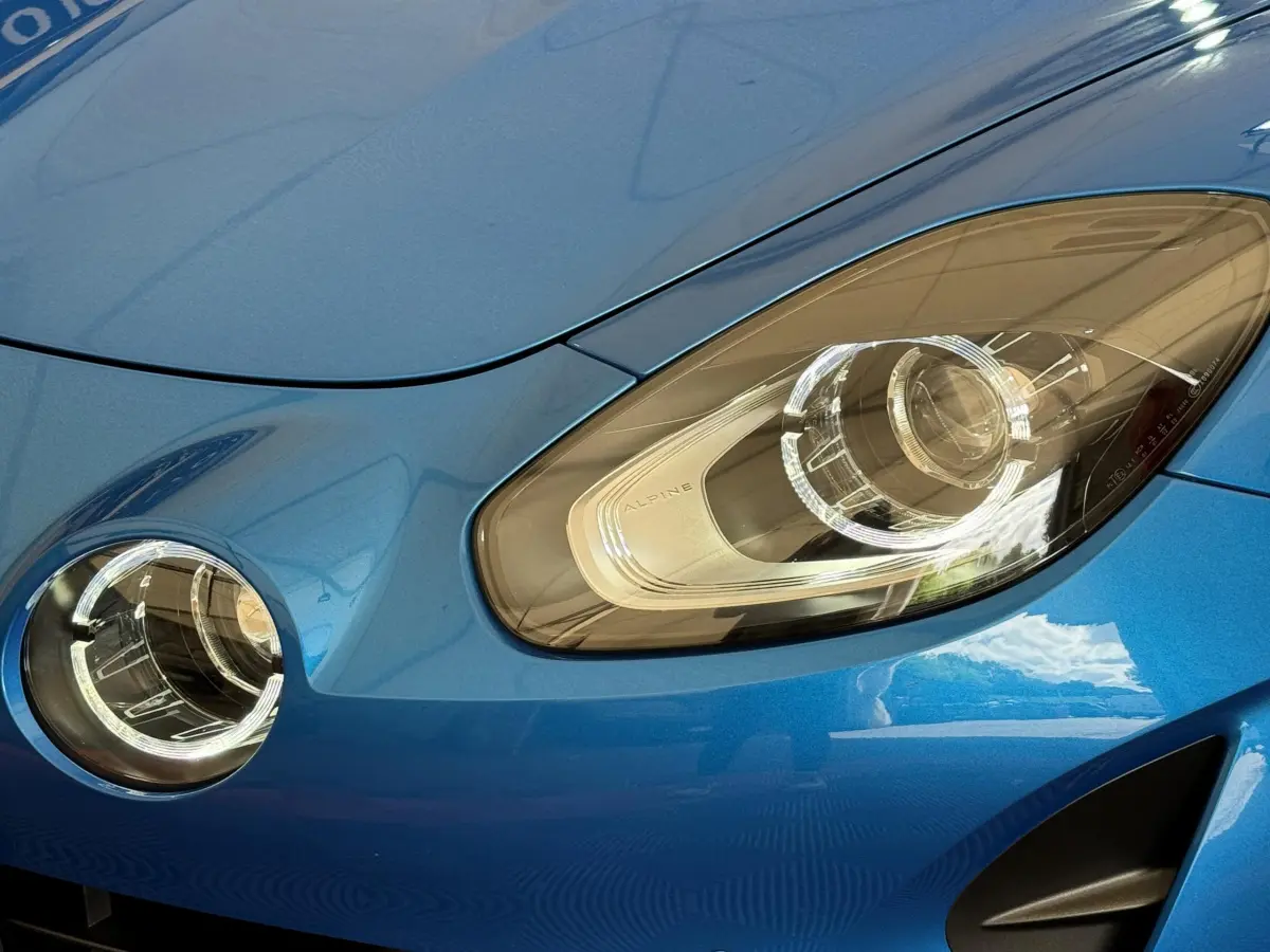 Gros plan sur le phare avant droit et le feu antibrouillard d'une Alpine A110 Légende bleue 2019.