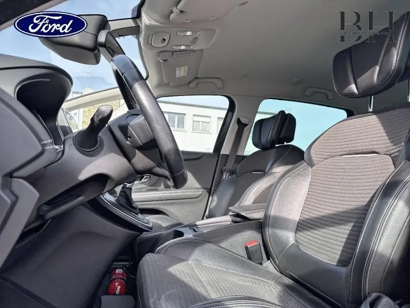 Vue intérieure côté conducteur du Renault Grand Scenic 2017 avec sièges en similicuir carbone foncé et volant cuir.