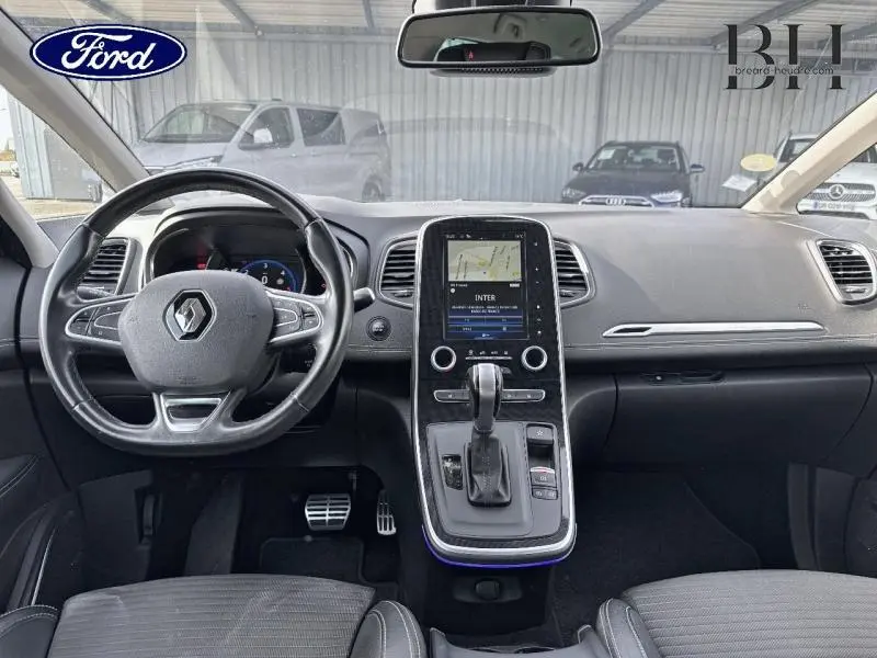 Vue intérieure avant du Renault Grand Scenic noir étoilé de 2017, avec tableau de bord et écran tactile central visible.