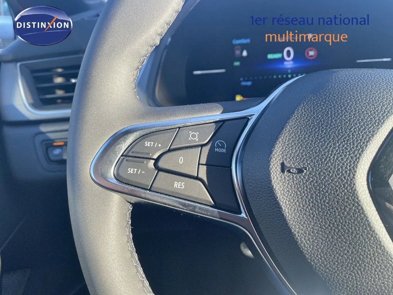 Gros plan sur le volant avec commandes intégrées du Renault Captur E-Tech hybride rouge passion toit noir, intérieur moderne.