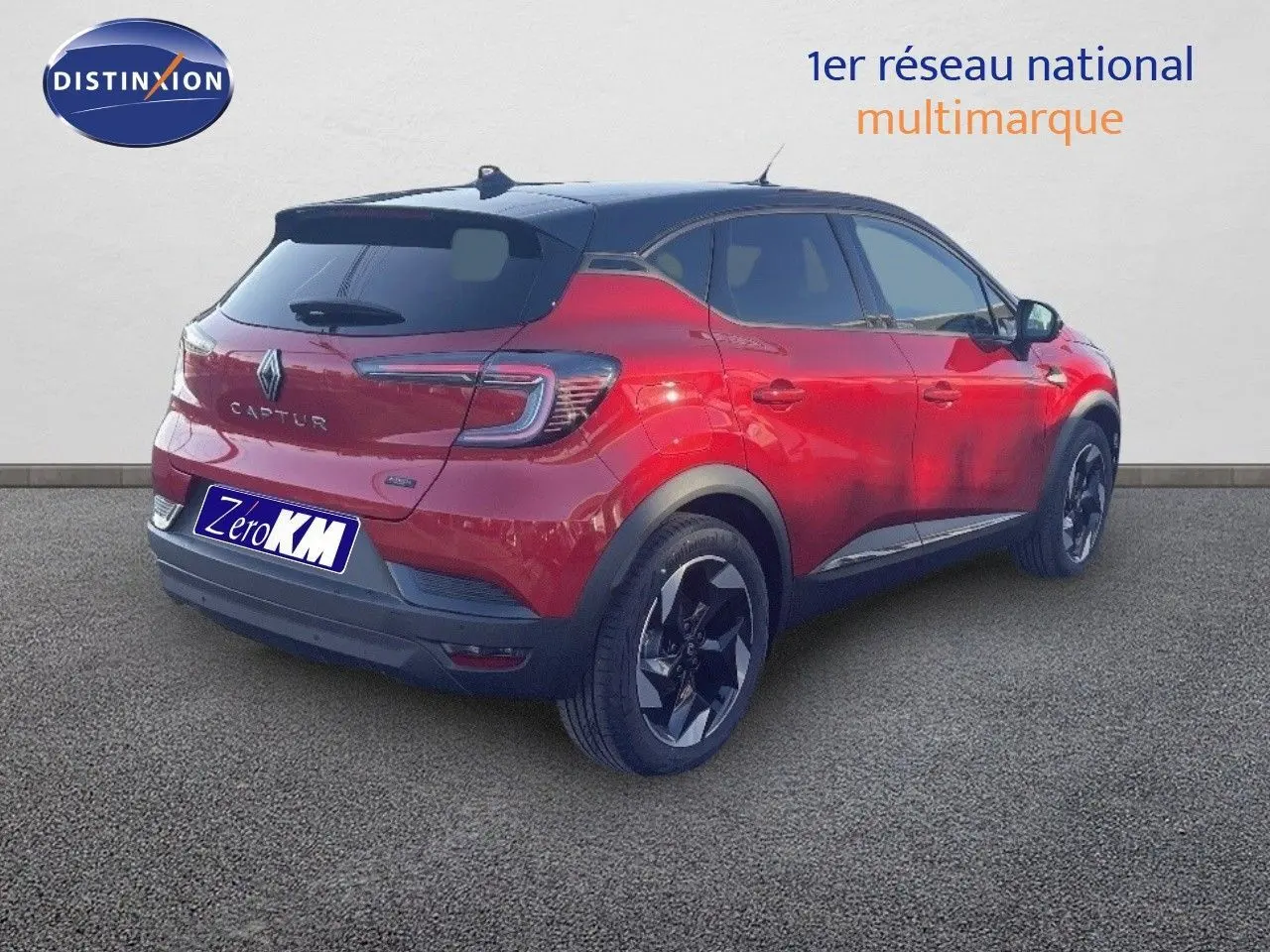 Vue 3/4 arrière droite d’un Renault Captur E-Tech hybride rouge passion avec toit noir et jantes noires.