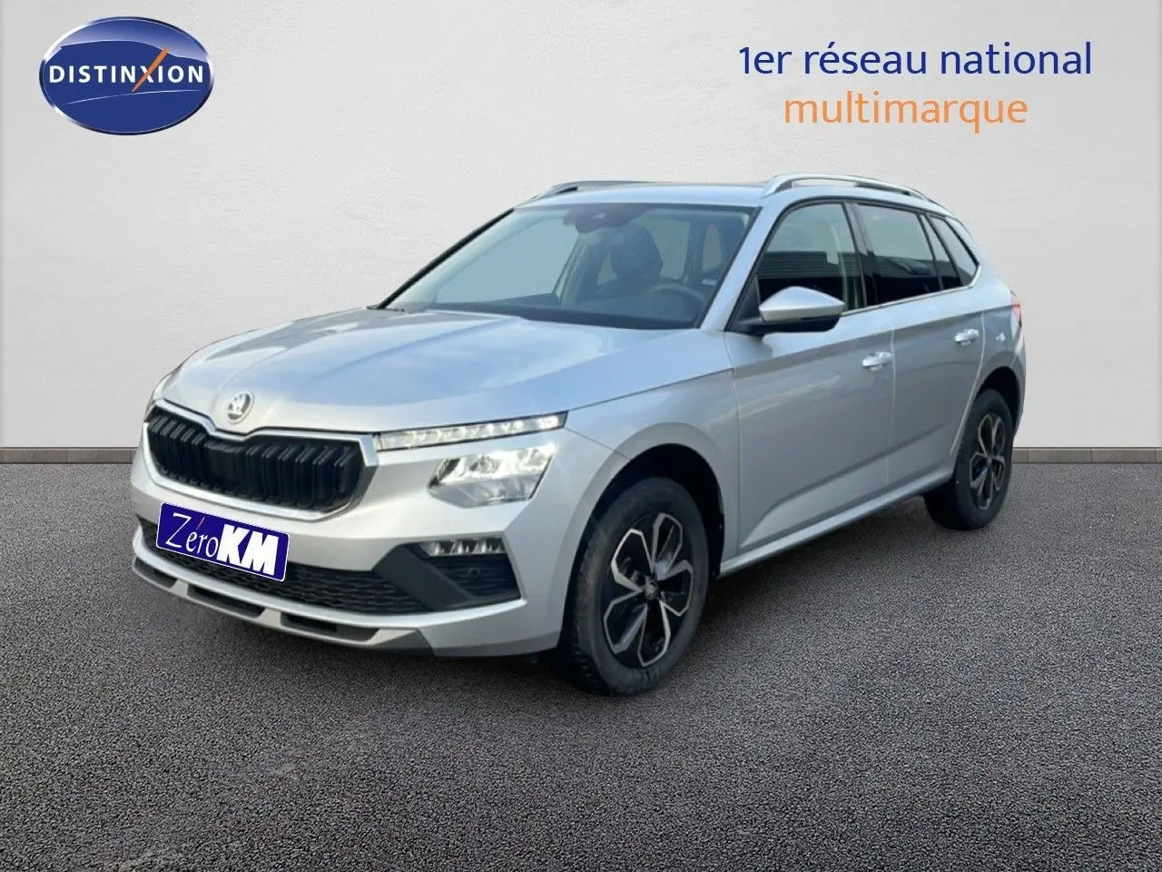 Vue 3/4 avant droite d'un Skoda Kamiq gris argent métallisé avec jantes bi-ton et calandre noire distinctive.