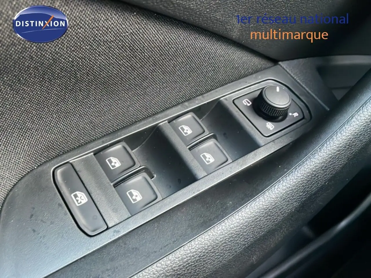 Gros plan sur les commandes des vitres électriques côté gauche d'une Skoda Kamiq gris argent métal.