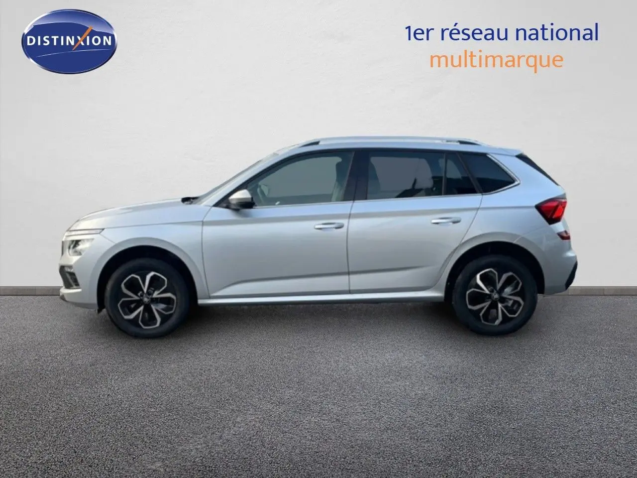 Vue de profil côté gauche d'un Skoda Kamiq gris argent métallisé avec jantes bi-ton et toit ouvrant.