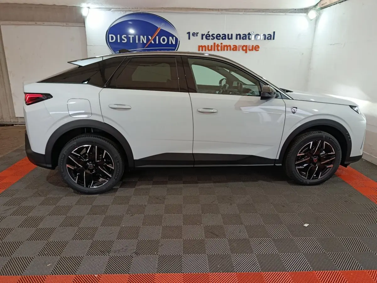 Vue latérale droite du Peugeot 3008 blanc hybride 2025 avec jantes noires et toit noir contrasté en intérieur showroom.