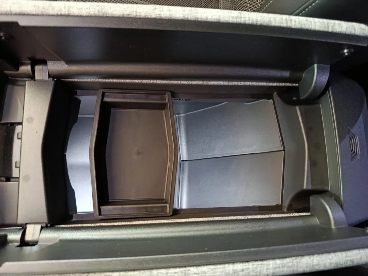 Vue en plongée du rangement central intérieur du Peugeot 3008 blanc hybride, montrant un compartiment noir modulable.