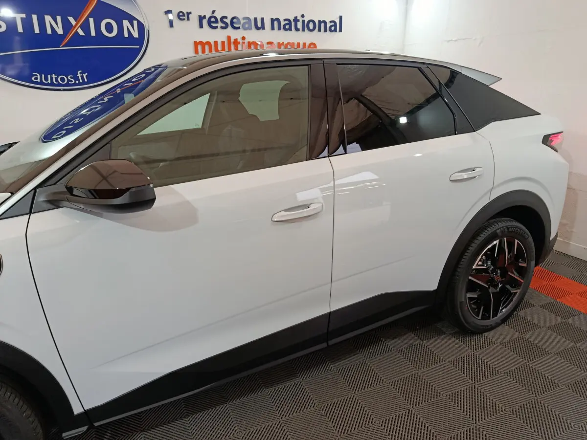 Profil droit d’un Peugeot 3008 blanc hybride 2025 avec jantes noires et toit noir contrasté.