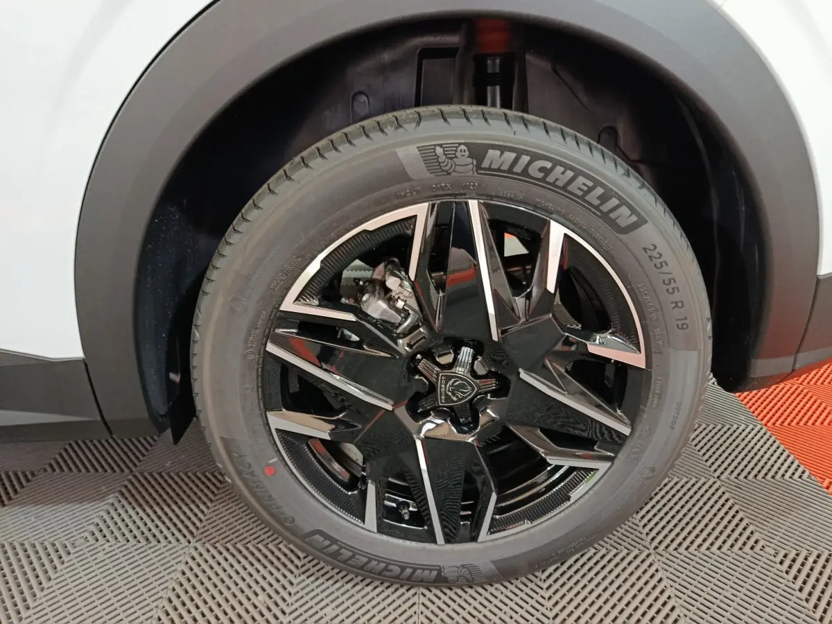 Gros plan sur la roue avant droite noire et chromée du Peugeot 3008 blanc, avec pneu Michelin visible.