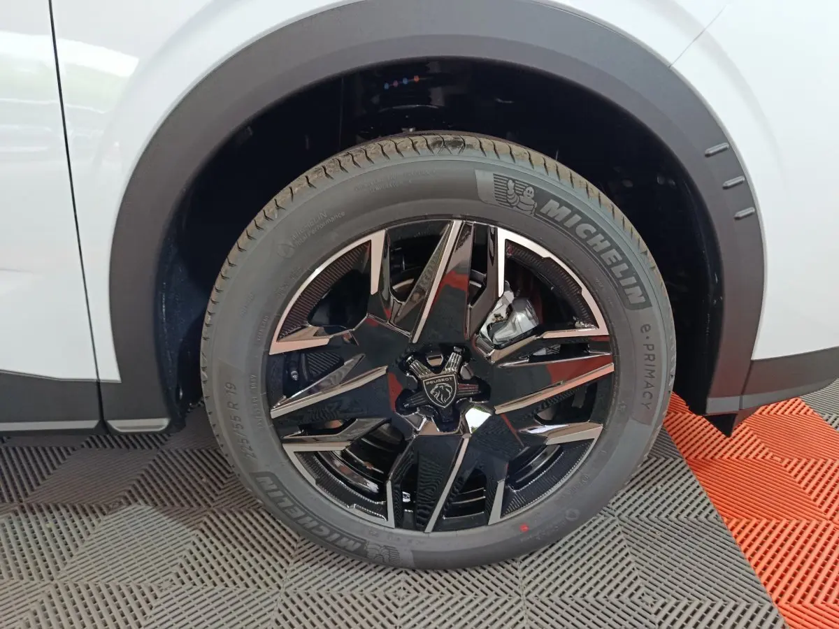 Gros plan sur la roue arrière droite noire et chromée du Peugeot 3008 blanc, avec pneu Michelin visible.