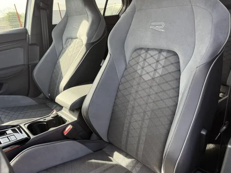 Vue rapprochée des sièges avant gris avec logo R brodé dans l'habitacle d'une Volkswagen Golf 2024.