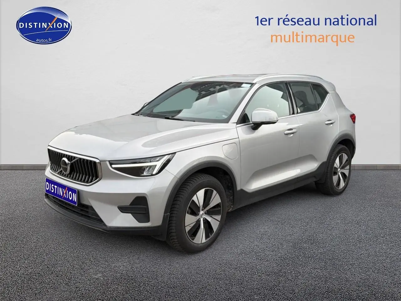 Volvo XC40 T4 hybride gris en 3/4 avant droit, avec jantes alu et calandre distinctive Volvo.
