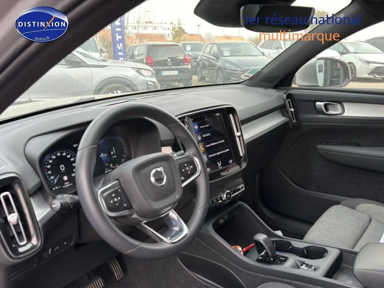 Intérieur du Volvo XC40 T4 hybride 2023, vue côté conducteur montrant tableau de bord et volant cuir noir.