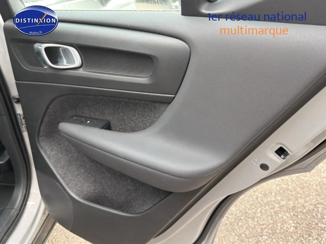 Vue rapprochée de la porte arrière droite grise du Volvo XC40 T4 recharge avec accoudoir et commande de vitre.