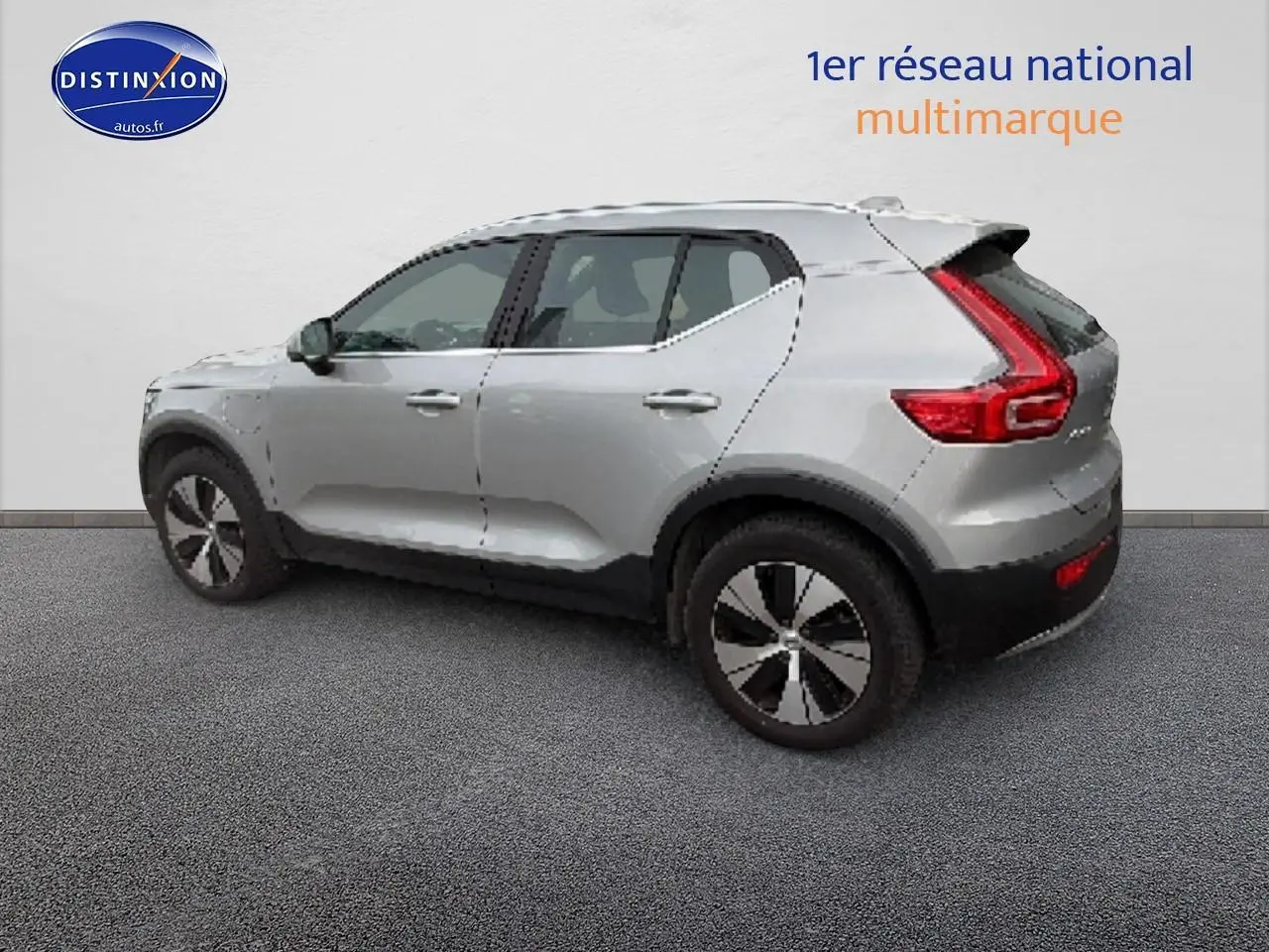 Vue de profil côté gauche d'un Volvo XC40 T4 hybride gris avec jantes alu et feux arrière en L distinctifs.