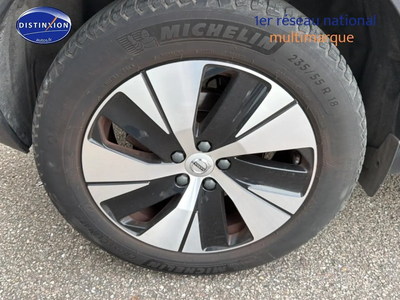Gros plan sur la jante alu bicolore et le pneu Michelin du Volvo XC40 gris, côté avant droit.
