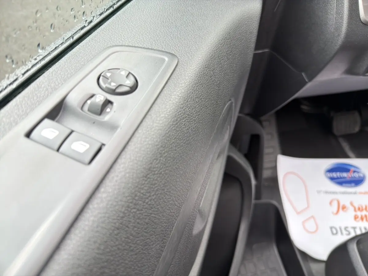 Gros plan sur la porte côté conducteur du Citroën Jumpy gris foncé, montrant les commandes des vitres électriques.