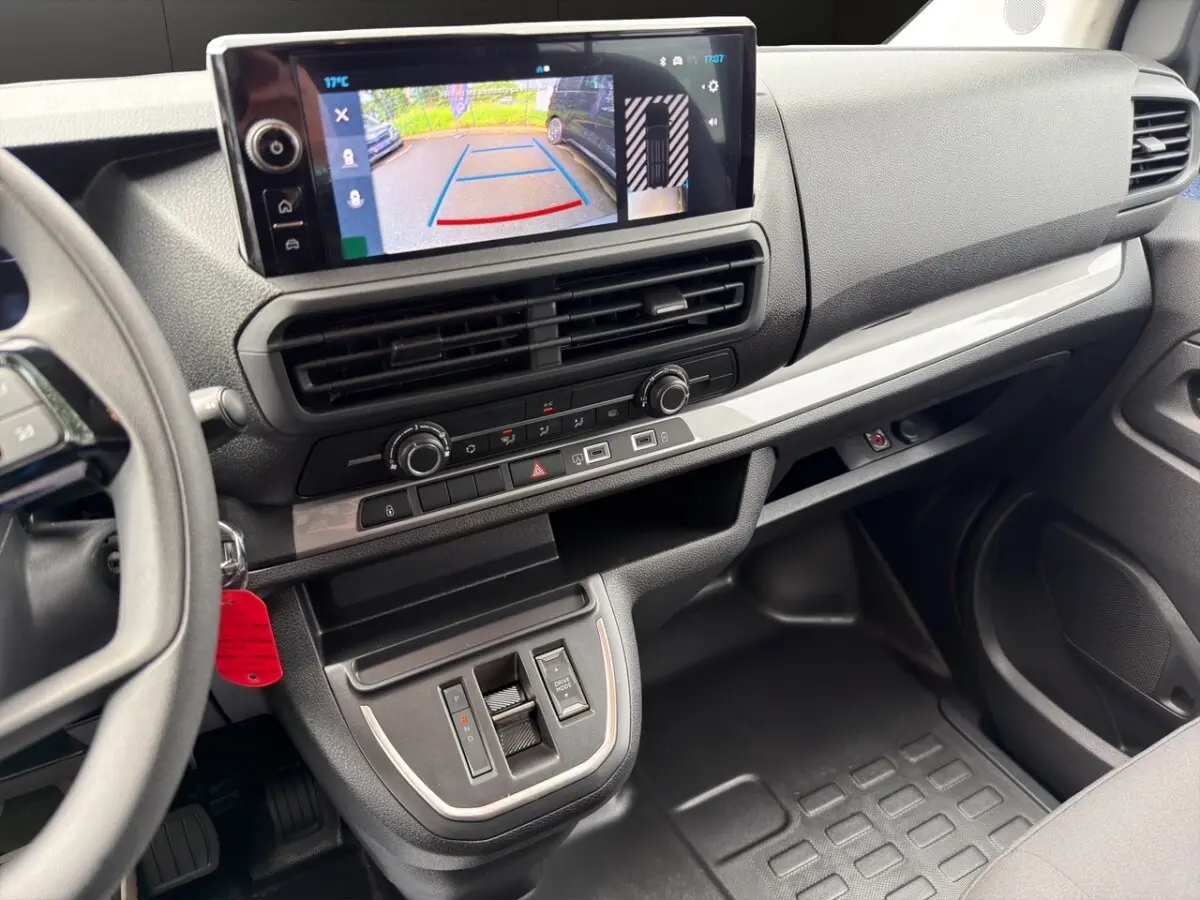 Vue intérieure du tableau de bord du Citroën Jumpy gris foncé, avec écran tactile affichant la caméra de recul.