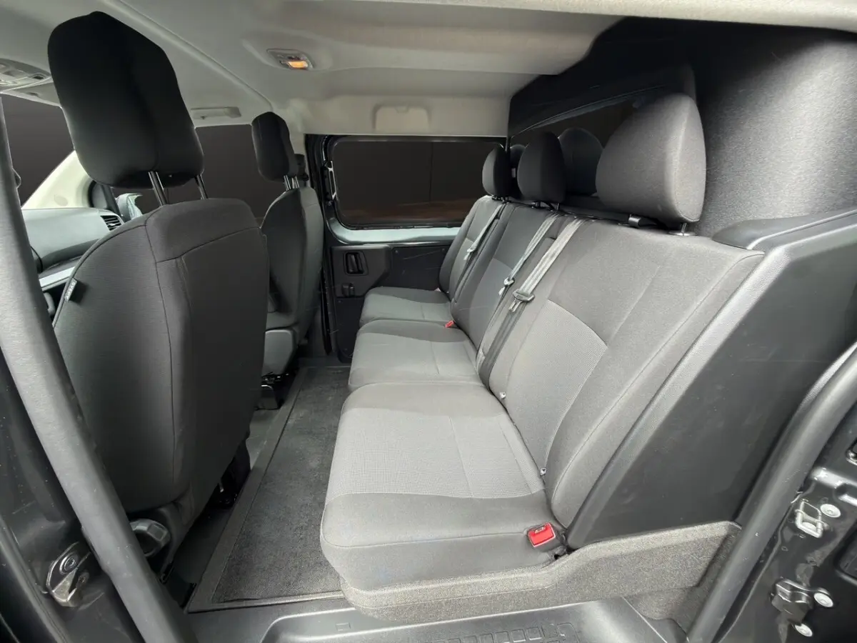Vue intérieure côté droit sur la banquette arrière grise du Citroën Jumpy XL 2026 avec cloison vitrée fixe.