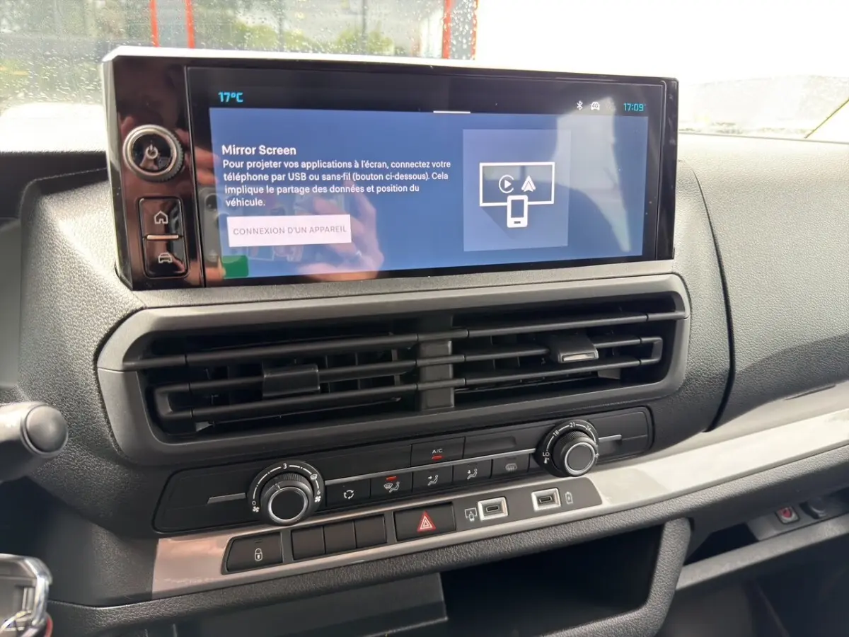 Vue rapprochée de la console centrale du Citroën Jumpy gris foncé, avec écran tactile et commandes de climatisation.