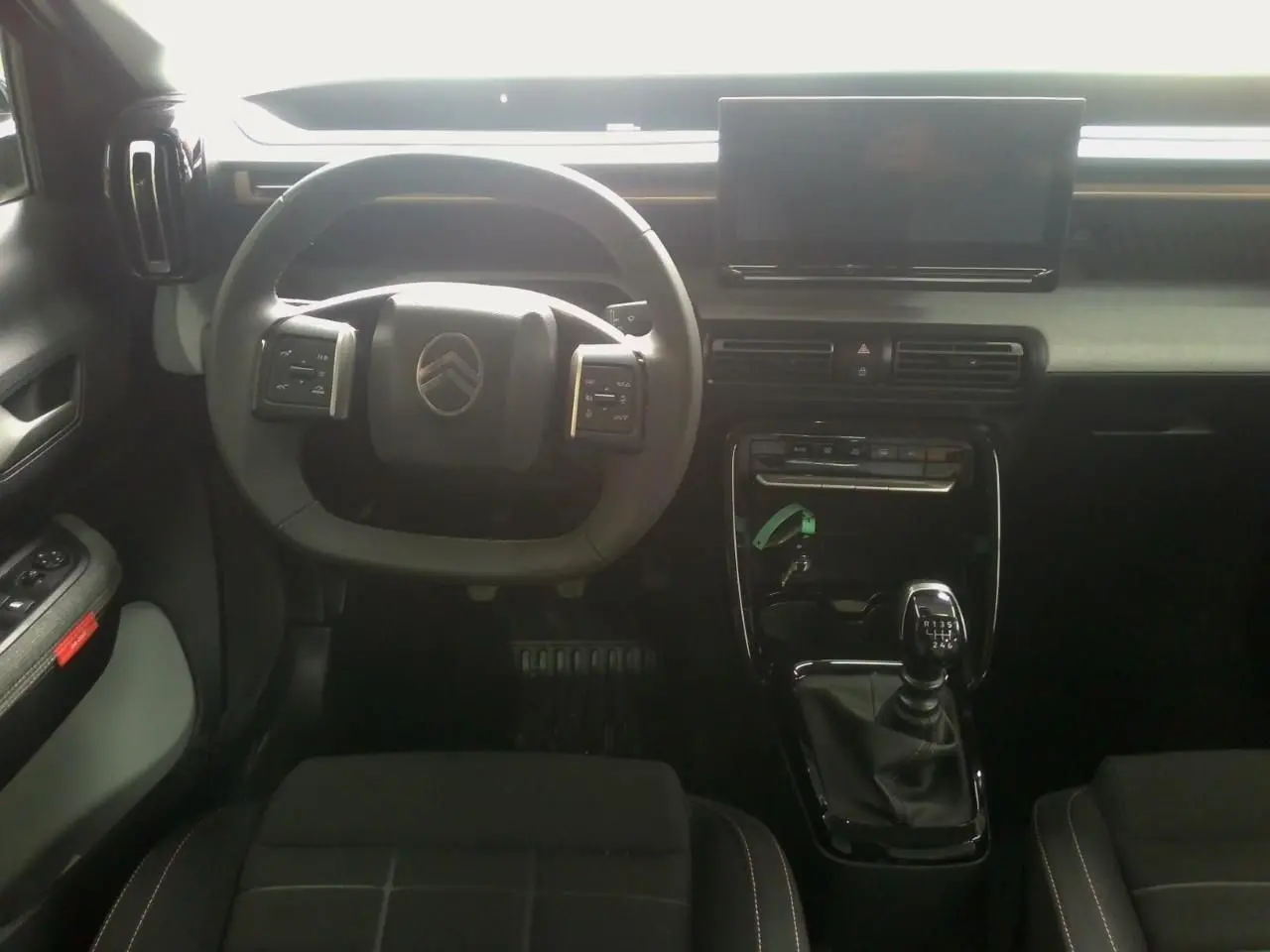 Vue intérieure centrée sur le volant et la console centrale avec boîte manuelle du Citroën C3 Aircross 2025.