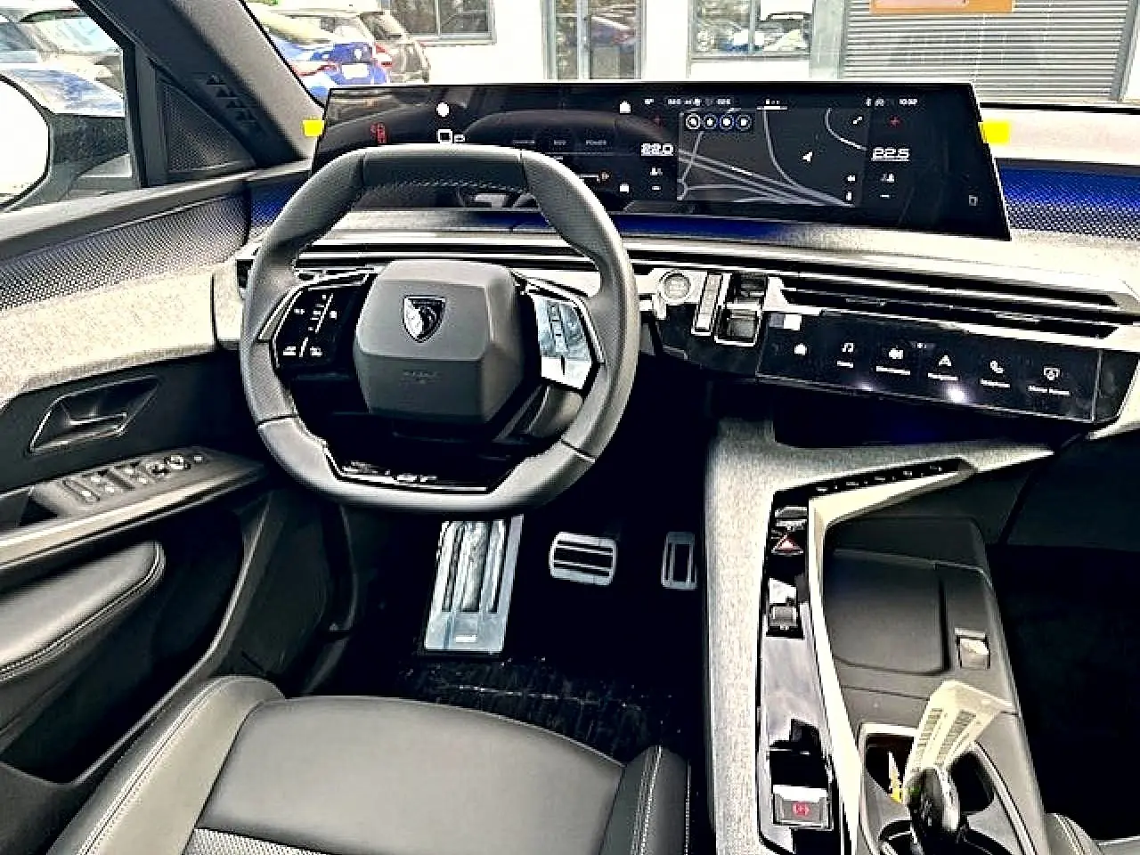 Vue intérieure avant du Peugeot 3008 1.2 hybrid gris titane, avec tableau de bord numérique et volant multifonction cuir.