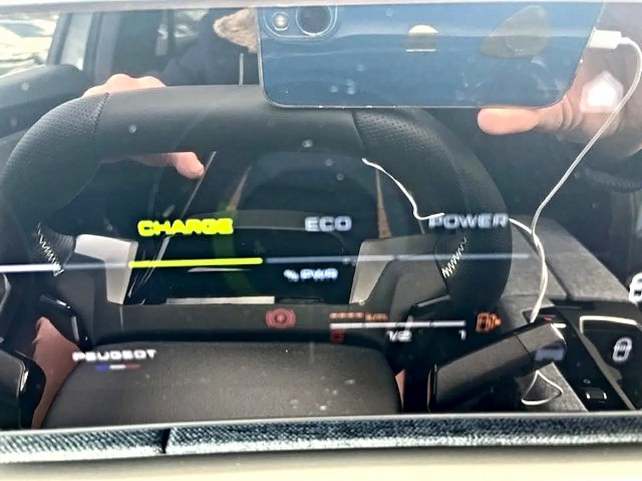 Vue rapprochée du tableau de bord numérique et volant cuir noir du Peugeot 3008 gris titane hybride 2025.