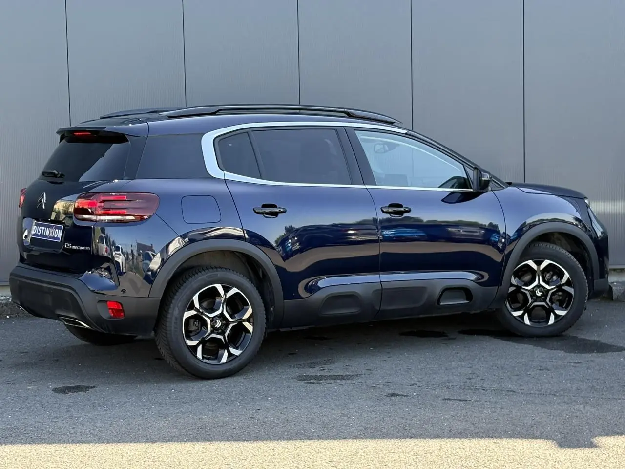 Vue latérale droite du Citroën C5 Aircross Hybrid bleu Eclipse avec jantes alliage et protections noires sur bas de caisse.