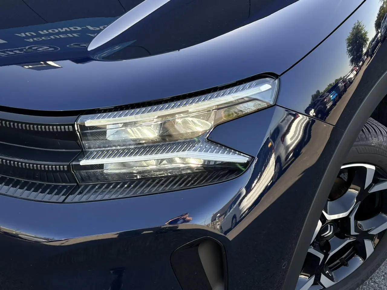 Gros plan sur l'avant droit bleu Eclipse du Citroën C5 Aircross Hybrid avec phares LED et jante alliage bi-ton.