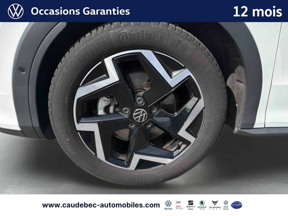 Gros plan sur la roue avant droite du Volkswagen T-Roc blanc avec jante alliage noir et argent brillante.
